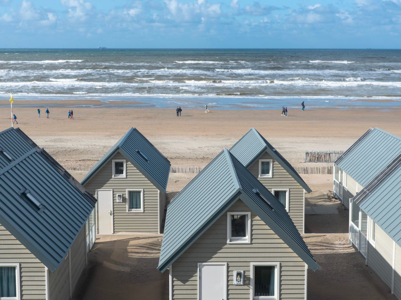Idyllic beachfront cabins with ocean view under blue skies, perfect for a serene getaway.